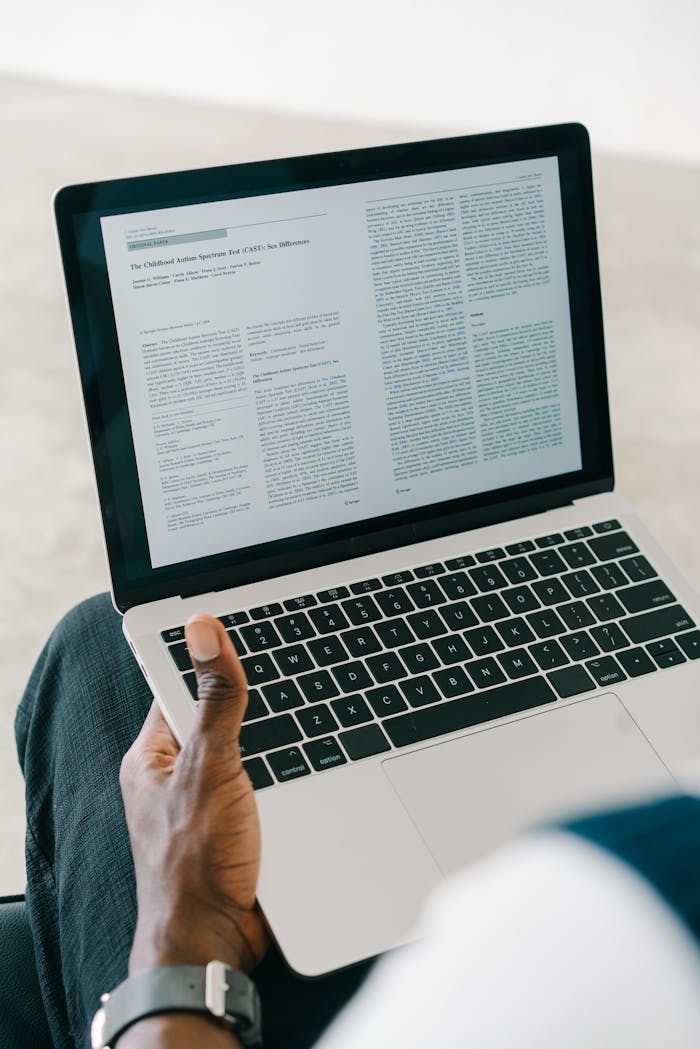 Close-up of a person viewing a document on a laptop screen indoors.